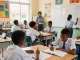 The 2026 waec timetable being written on a whiteboard in a vibrant classroom with students actively engaged in learning.